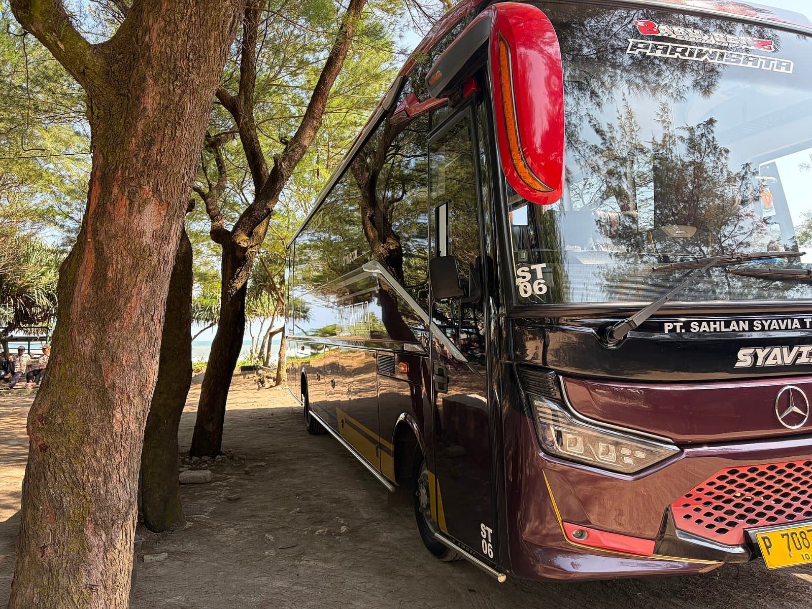 Bus pariwisata terparkir di tepi pantai